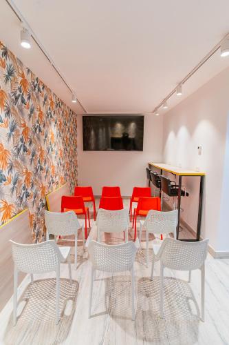 a waiting room with red chairs and a table at APTC ETXEa in Vitoria-Gasteiz