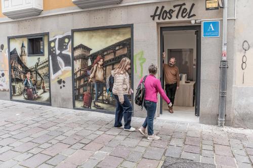 two people standing outside of a shop with a mural at APTC ETXEa in Vitoria-Gasteiz
