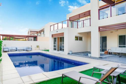 a villa with a swimming pool and a house at Luxurious 6-BHK Villa with Private Pool in Malibu in Ras al Khaimah