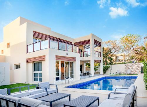 a villa with a swimming pool and a house at Luxurious 6-BHK Villa with Private Pool in Malibu in Ras al Khaimah