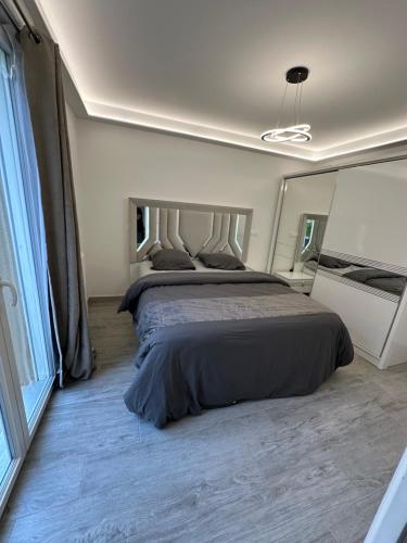 une chambre avec un grand lit et une grande fenêtre dans l'établissement Appartement avec jardin cosy près de Paris, à Villeneuve-le-Roi