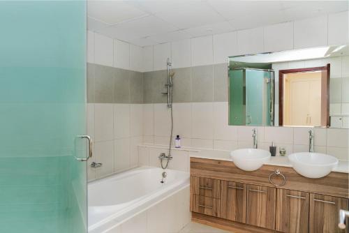 a bathroom with a tub and a sink and a bath tub at Luxurious 6-BHK Villa with Private Pool in Malibu in Ras al Khaimah