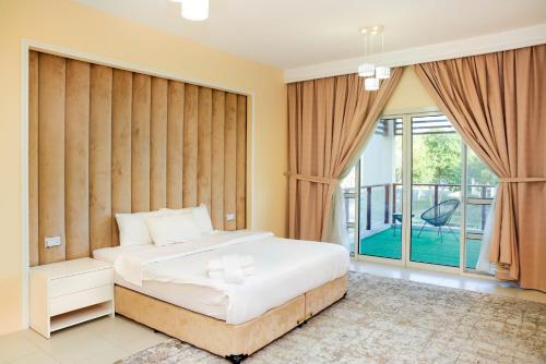 a bedroom with a bed and a balcony at Luxurious 6-BHK Villa with Private Pool in Malibu in Ras al Khaimah