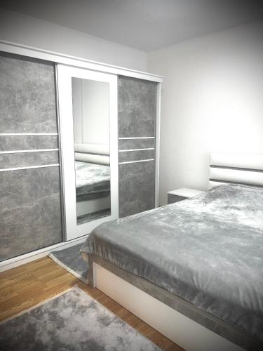 a bedroom with a bed and a large window at Falcon Apartment in Brezovicë