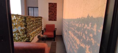 a room with a red chair and a wall at Serene Hills Home in Nairobi
