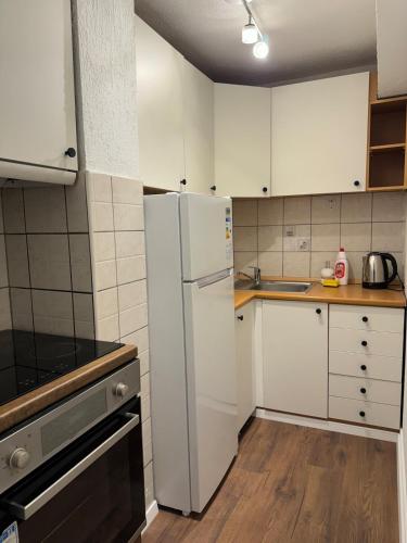 a kitchen with white cabinets and a refrigerator at ApartmentGjilanCenter in Gjilan