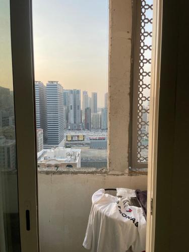 an open window with a view of a city at Comfortable Apartment Bedroom And Spacious Living Room Family and Couple in Sharjah