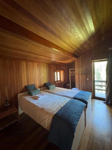 a bedroom with a large bed in a wooden room at Casa do Rio, Sever do Vouga in Paradela