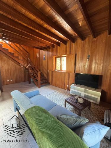 a living room with a blue couch and a television at Casa do Rio, Sever do Vouga in Paradela
