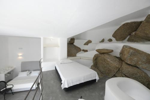 a bedroom with two beds and a rock wall at Lux Private Estate Endless Sea & Sky View in Plintri