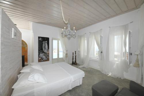 a white bedroom with a bed and a chandelier at Lux Private Estate Endless Sea & Sky View in Plintri