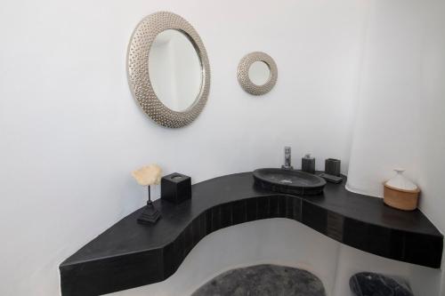 a bathroom with a black counter and a mirror at Lux Private Estate Endless Sea & Sky View in Plintri