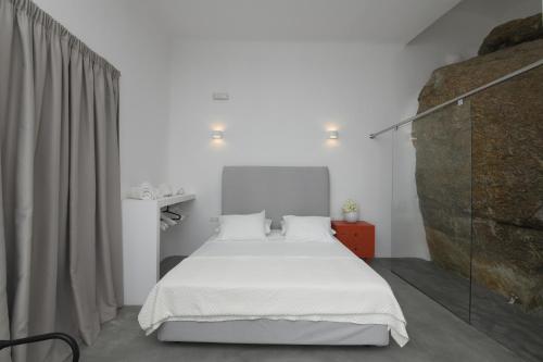 a bedroom with a bed with white sheets and pillows at Lux Private Estate Endless Sea & Sky View in Plintri