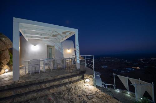 a white house with a table and chairs at night at Lux Private Estate Endless Sea & Sky View in Plintri
