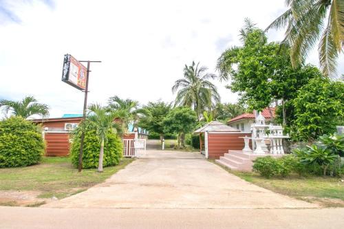 a road leading to a building with palm trees at The Rome Resort in Pran Buri