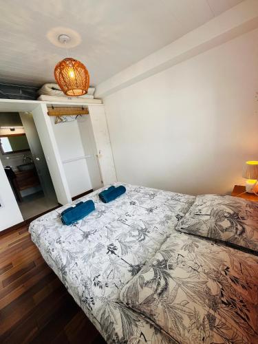 a bedroom with a bed with two blue pillows on it at Kay Ti Mabouya in Sainte-Luce