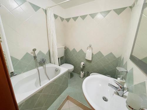 a bathroom with a sink and a tub and a toilet at Villa La Brace in Briatico