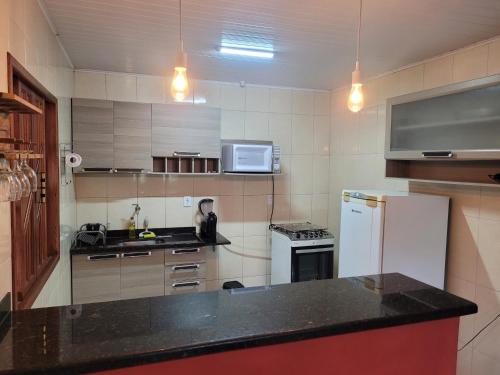 a kitchen with a white refrigerator and a microwave at Espaço inteiro: Casa de campo nas montanhas in Domingos Martins