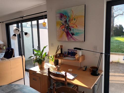 un bureau avec un bureau et une peinture sur le mur dans l'établissement Maison entre Nantes et l'océan, à Brains