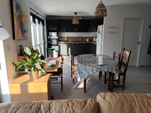 une cuisine et une salle à manger avec une table et des chaises dans l'établissement Maison entre Nantes et l'océan, à Brains