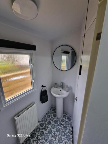 a small bathroom with a sink and a mirror at Forest Valley Holiday Home in Ballantrae