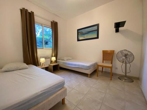 - une chambre avec 2 lits et un ventilateur dans l'établissement Bel appartement 120m2 proche plages et Porto Pollo, à Serra-di-Ferro