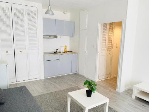 - une cuisine blanche avec des placards blancs et une table dans l'établissement Studio accès direct à la gare, à Marseille