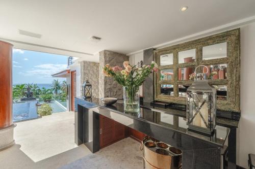 a kitchen with a counter with a vase of flowers at Villa Gecko with sea view pool, walk to Beach & Restaurants in Surin Beach