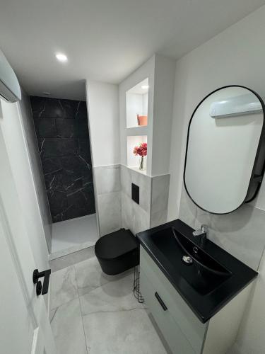 une salle de bain avec un lavabo noir et un miroir dans l'établissement Flower power in Lyon neuf climatisé avec terrasse, à Vénissieux