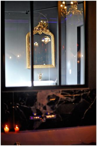 a window of a store with chandeliers in it at La majestueuse, SPA XXL, Day use, Suite de luxe, 5 min centre in Bourgoin