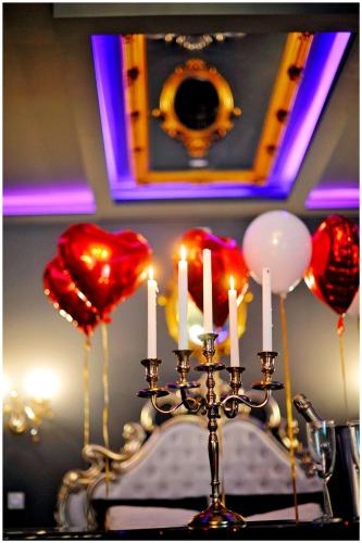 a chandelier with candles and red hearts and balloons at La majestueuse, SPA XXL, Day use, Suite de luxe, 5 min centre in Bourgoin