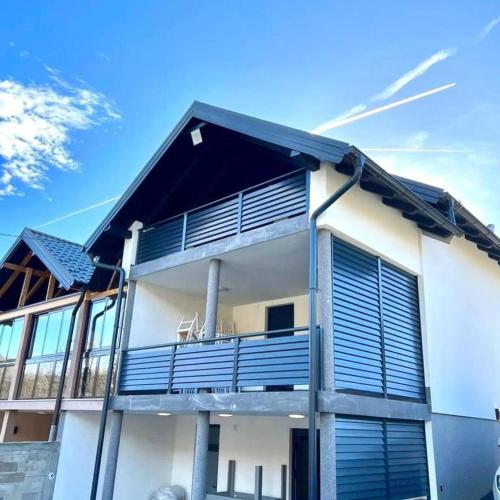 a house with blue balconies on the side of it at Villa Imperia for rent - Banja Luka Krupa na Vrbasu in Krupa na Vrbasu