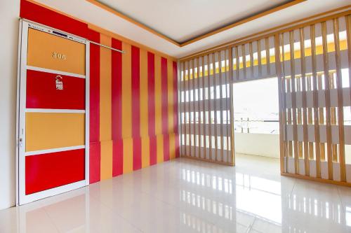 een kamer met kleurrijke gestreepte muren en deuren bij Restu Inn in Lampung