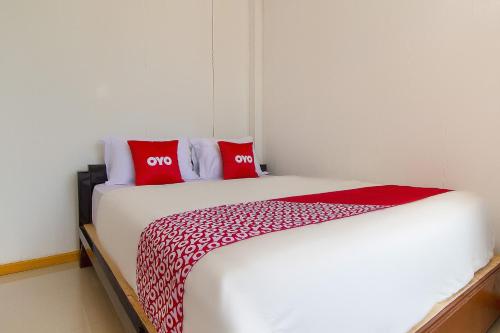 a bedroom with a bed with two red pillows at Hotel O Restu Inn in Lampung