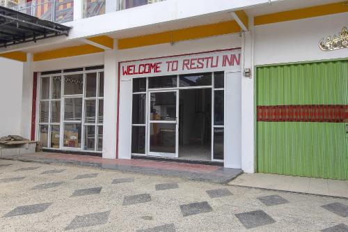 een gebouw met een bord waarop staat: welkom om te herstarten ntn bij Restu Inn in Lampung