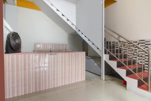 a staircase in a building with a pink wall at Hotel O Restu Inn in Lampung