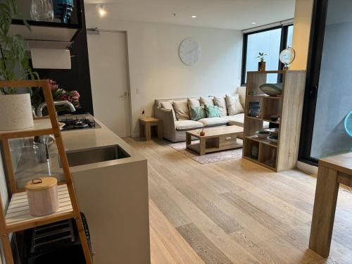 a living room with a couch and a table at City Fringe Oasis - Pool, Gym & Car Park in Melbourne