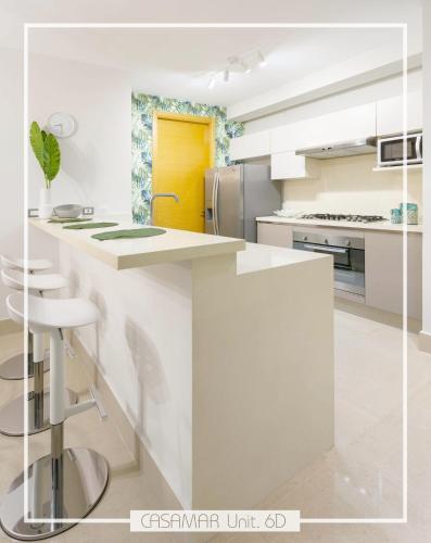 a white kitchen with a yellow door at Escapada Exclusiva en Casamar, playa surf y golf in San Carlos