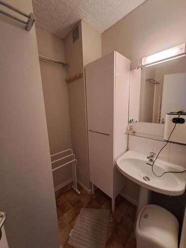 une salle de bain avec un lavabo, des toilettes et un miroir dans l'établissement Dune and sea view T2, à Saint-Hilaire-de-Riez