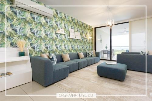 a living room with a blue couch and a mural at Escapada Exclusiva en Casamar, playa surf y golf in San Carlos