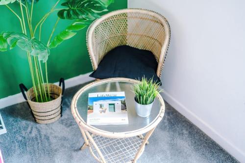 a wicker chair with a glass table and plants at 17 Anfield House sleeps 12 7min walk to stadium in Liverpool