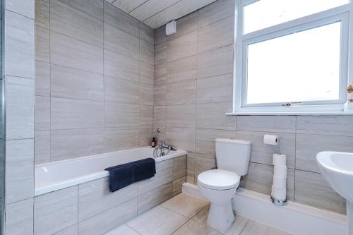 a bathroom with a toilet and a tub and a sink at 17 Anfield House sleeps 12 7min walk to stadium in Liverpool