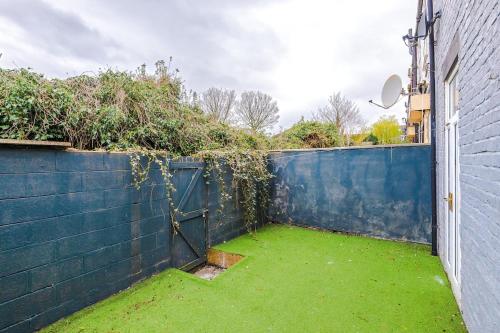 a garden with a blue fence with a door at 17 Anfield House sleeps 12 7min walk to stadium in Liverpool