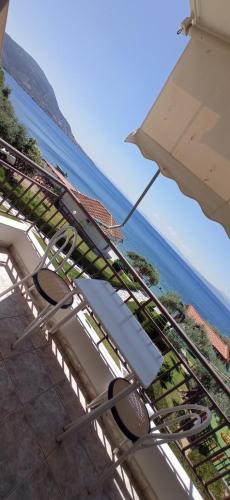 a chair and an umbrella next to the ocean at MAKRIS Studios in Yiáltra