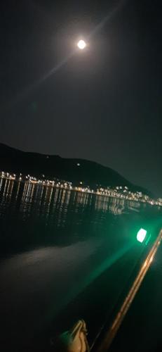 a moon over the water at night with a street at MAKRIS Studios in Yiáltra