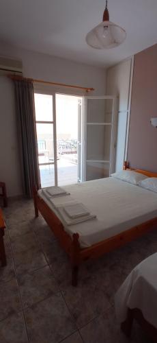 a bedroom with a large bed and a large window at MAKRIS Studios in Yiáltra