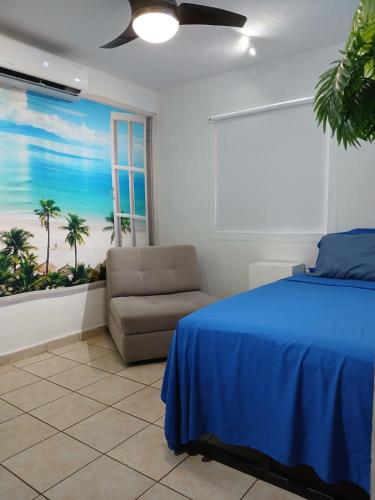 a bedroom with a blue bed and a couch at Autentico y Lindo Departamento in Puerto Vallarta