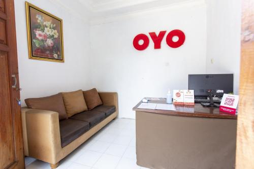 a office with a couch and a desk with a computer at Hotel O near Metropolitan Mall formerly Sakura Home Stay in Kaum