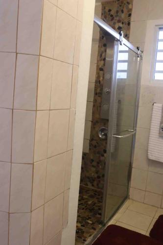 a shower with a glass door in a bathroom at Tamara Guest House in Luquillo