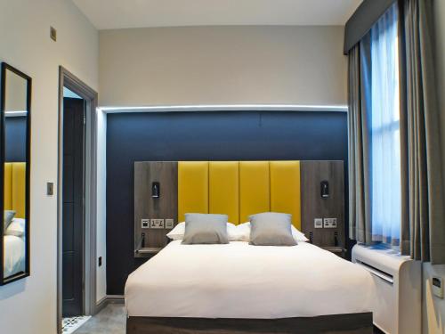 a bedroom with a large white bed with two pillows at OYO Tamworth Arms Boutique Pub & Hotel in Tamworth